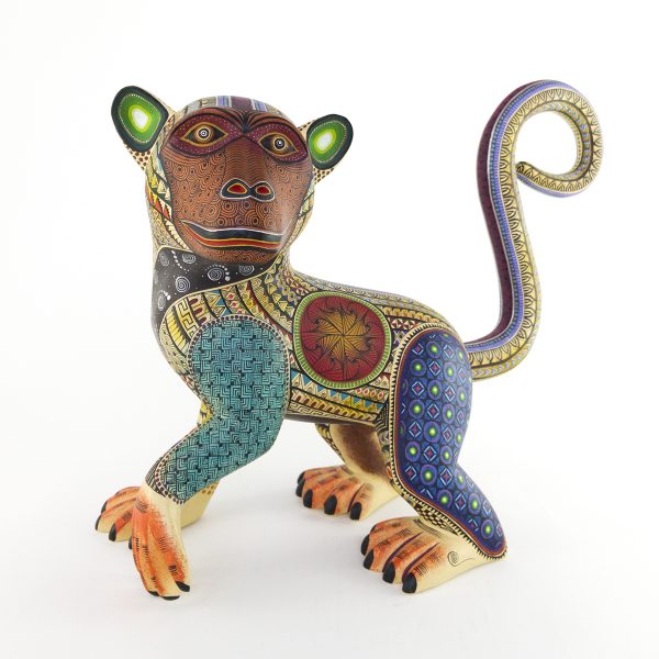 Beautiful smiley monkey alebrije painted in delicate patterns. Yellow body, brown face, blue legs and a detachable tail.